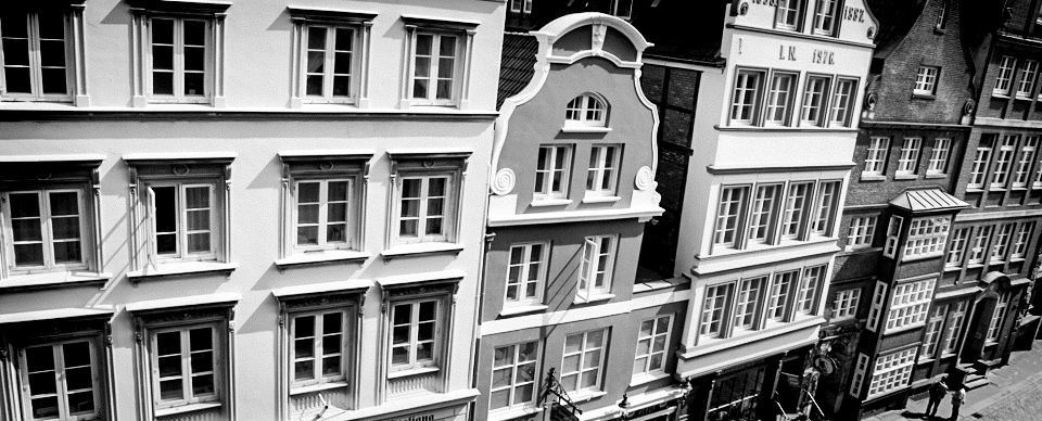 Schwarz-Weiß-Bild von historischen Gebäuden mit Fensterfronten in der Stadt. zu sehen ist die Deichstrasse in Hamburg.