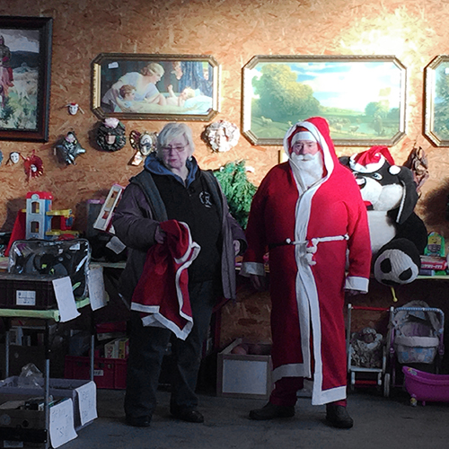 Eine Frau neben einem Mann mit Weihnachtsmannkostüm auf einem Flohmarkt