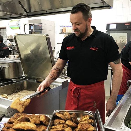 Mann macht in Küche Schnitzel