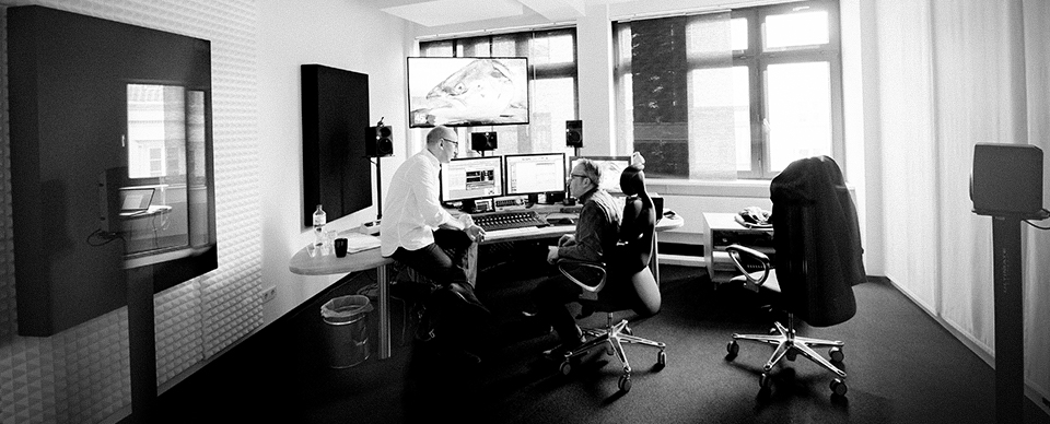 Zwei Männer sitzen in einem Tonstudio und unterhalten sich