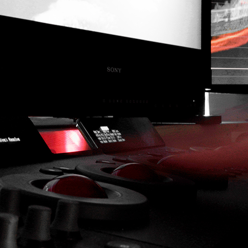 Unscharfe Hand bei der Farbkorrekturüber Tangent Wave Pult vor Sony-4K-HDR-Klasse A-Monitor